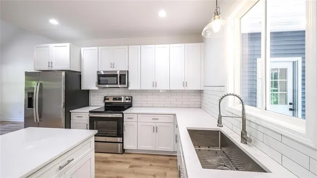 a kitchen with granite countertop a stove a sink and a refrigerator