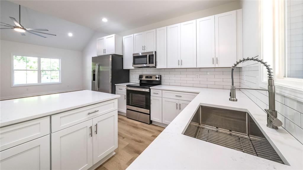 128 Pollard Road Temple, GA 30179 - Photo 12 of 36 a kitchen with granite countertop a sink stainless steel appliances and cabinets