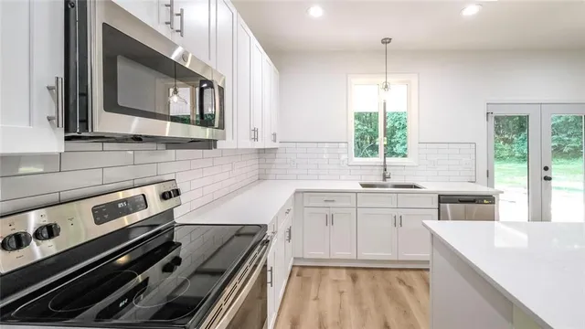 a kitchen with a stove a sink and a microwave