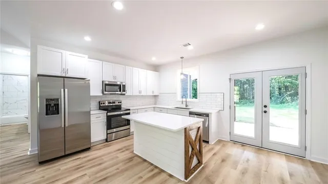 a kitchen with a sink a counter top stainless steel appliances and cabinets