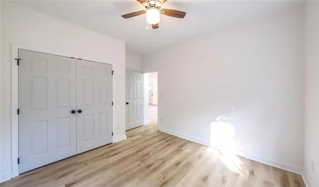 a view of a livingroom with a ceiling fan & hardwood floor