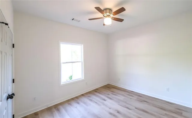 an empty room with a window and a fan