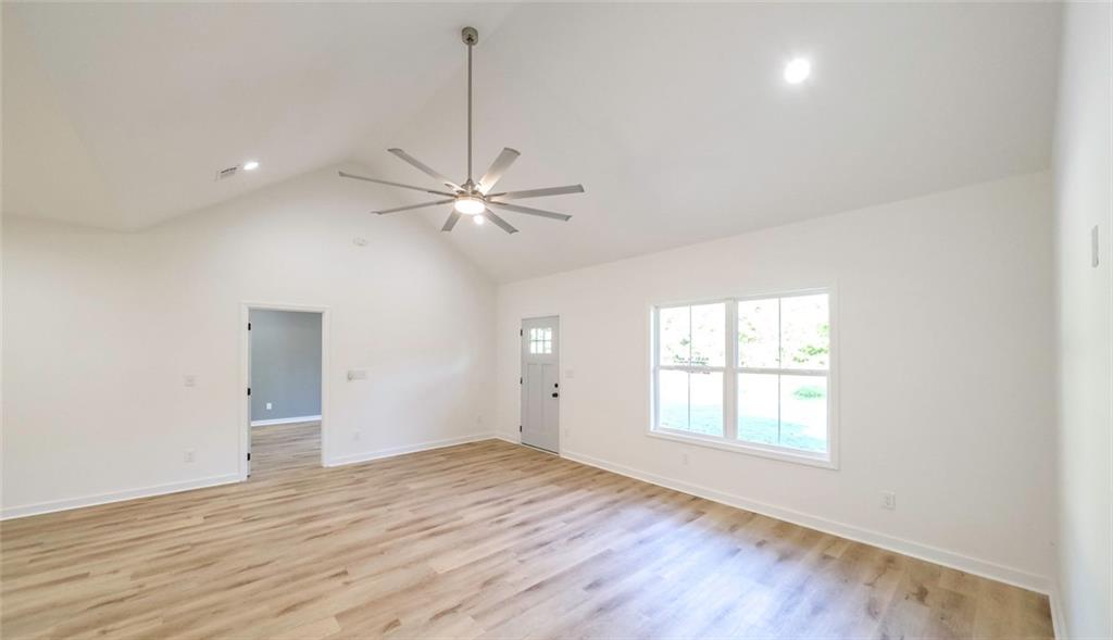 128 Pollard Road Temple, GA 30179 - Photo 4 of 36 an empty room with wooden floor fan and windows