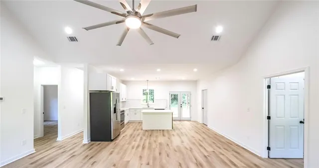 a kitchen with stainless steel appliances a refrigerator and a hard wood floor
