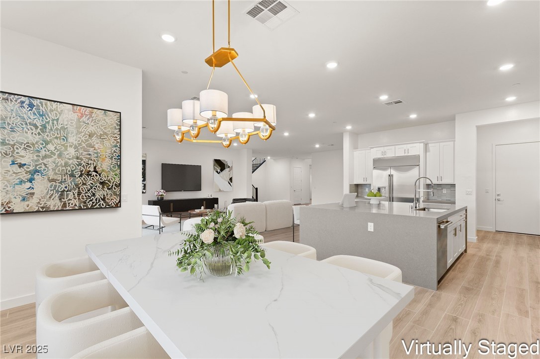 522 Riley Ridge Henderson, NV 89012 - Photo 8 of 53 Virtually Staged. Dining area features a modern chandelier, light wood-style floors