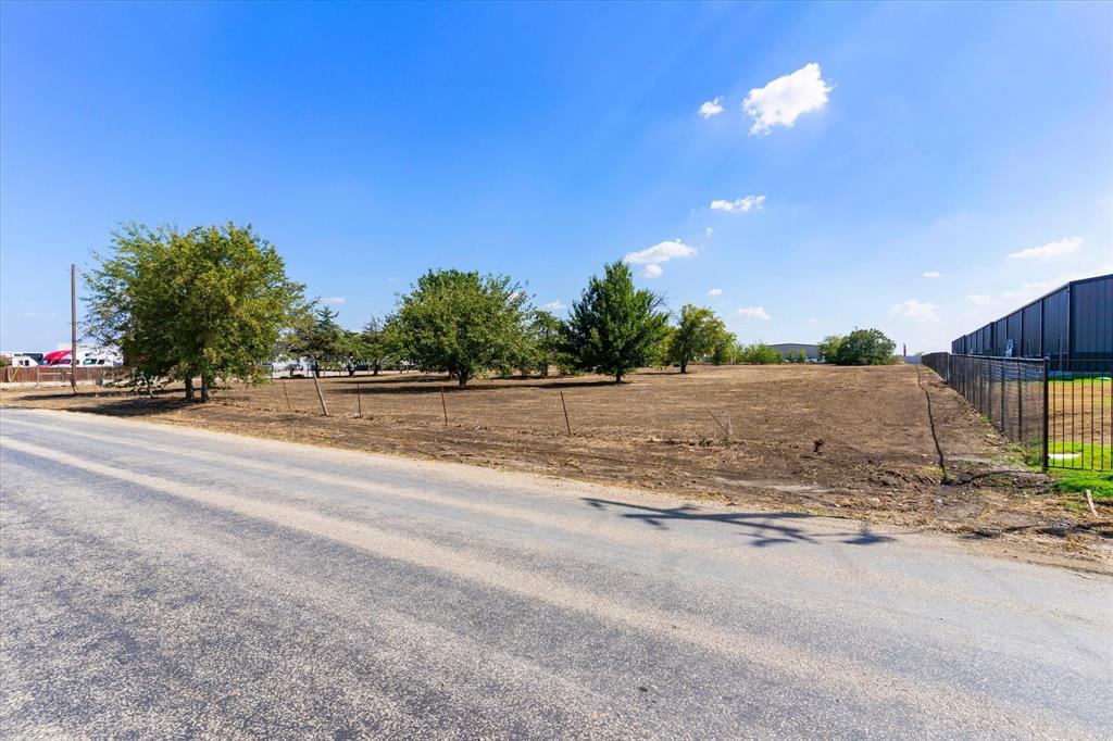 17326 Gaffield Road Justin, TX 76247 - Photo 5 of 21 Expansive lot featuring mature trees, a perimeter fence, and direct paved road frontage