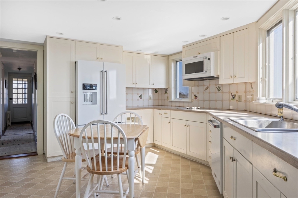 504 Old Harbor Road Chatham, MA 02633 - Photo 17 of 42 a kitchen with stainless steel appliances granite countertop a white table and chairs