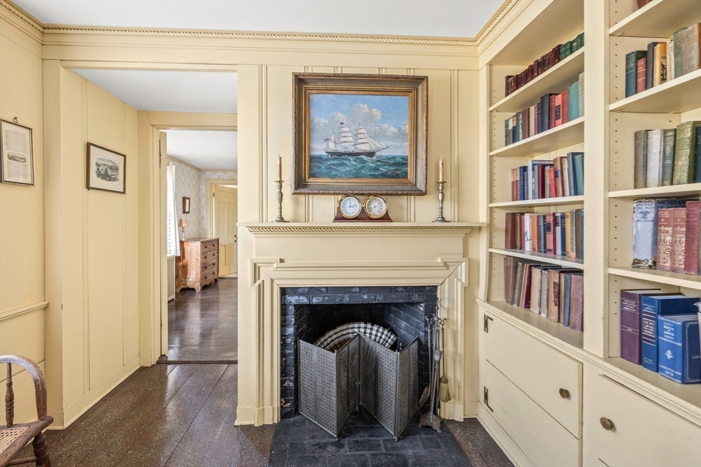 504 Old Harbor Road Chatham, MA 02633 - Photo 24 of 42 a living room with fireplace and a book shelf