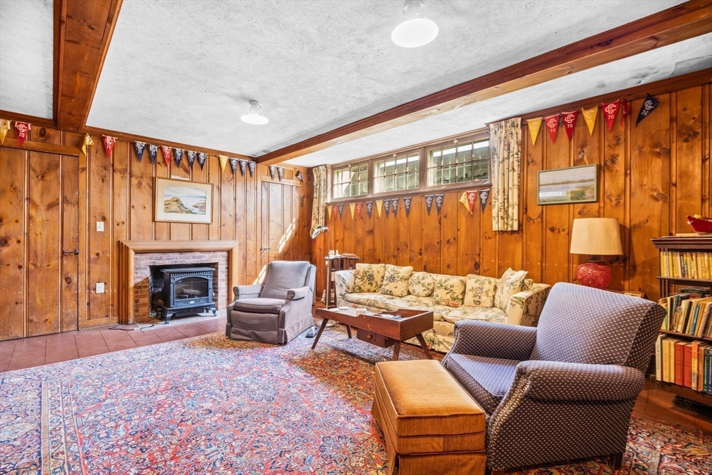 504 Old Harbor Road Chatham, MA 02633 - Photo 32 of 42 a living room with furniture a fireplace and a large window