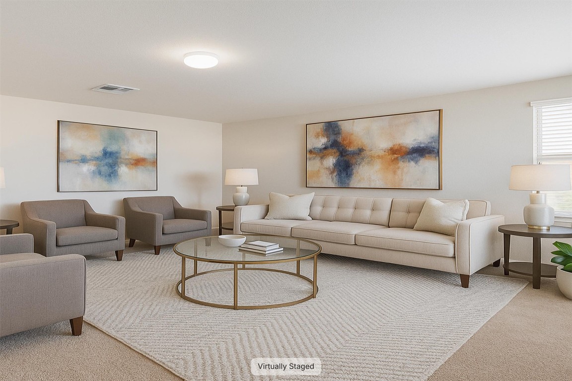 11620 Carbrook Road Manor, TX 78653 - Photo 26 of 40 a living room with furniture a couch and painting on the wall