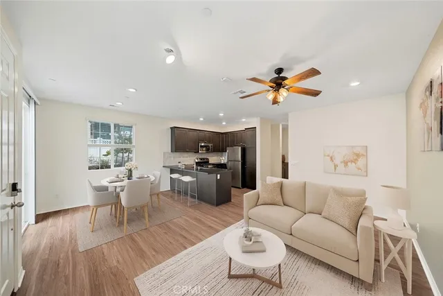 a living room with furniture kitchen view and a window