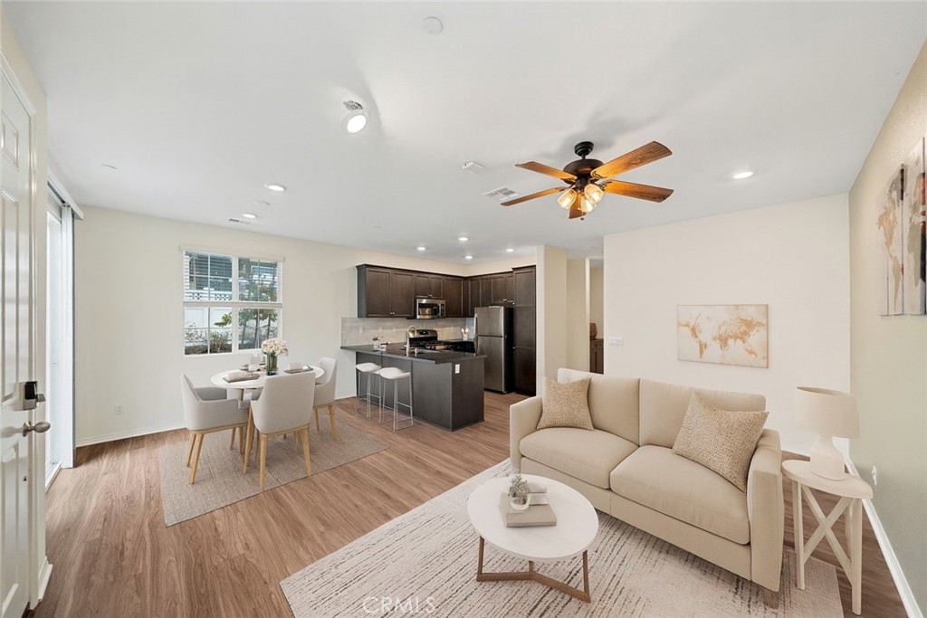 a living room with furniture kitchen view and a window