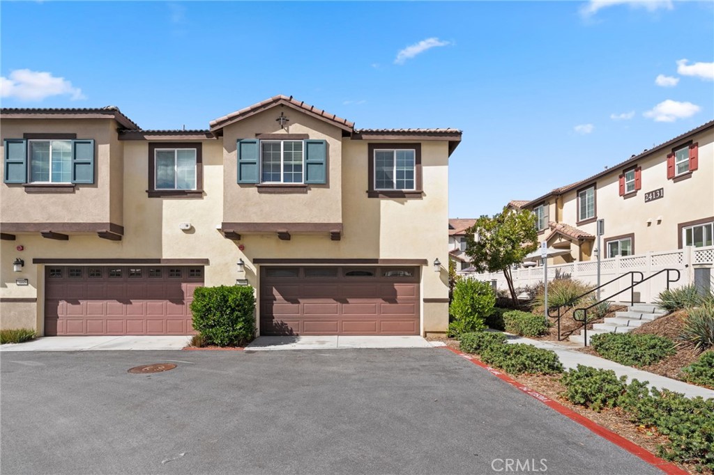 41979 Rondo Street, Unit 1106 Murrieta, CA 92562 - Photo 15 of 18 a front view of a house with a yard and garage