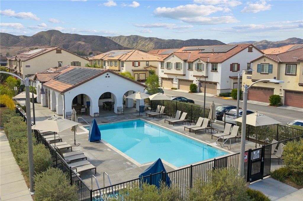 41979 Rondo Street, Unit 1106 Murrieta, CA 92562 - Photo 17 of 18 a view of a patio with couches table and chairs under an umbrella