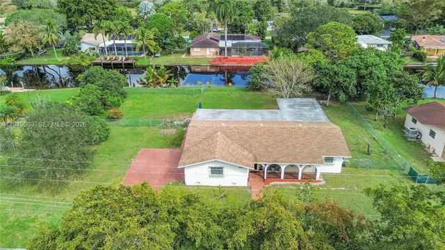 an aerial view of a house with a yard and lake view