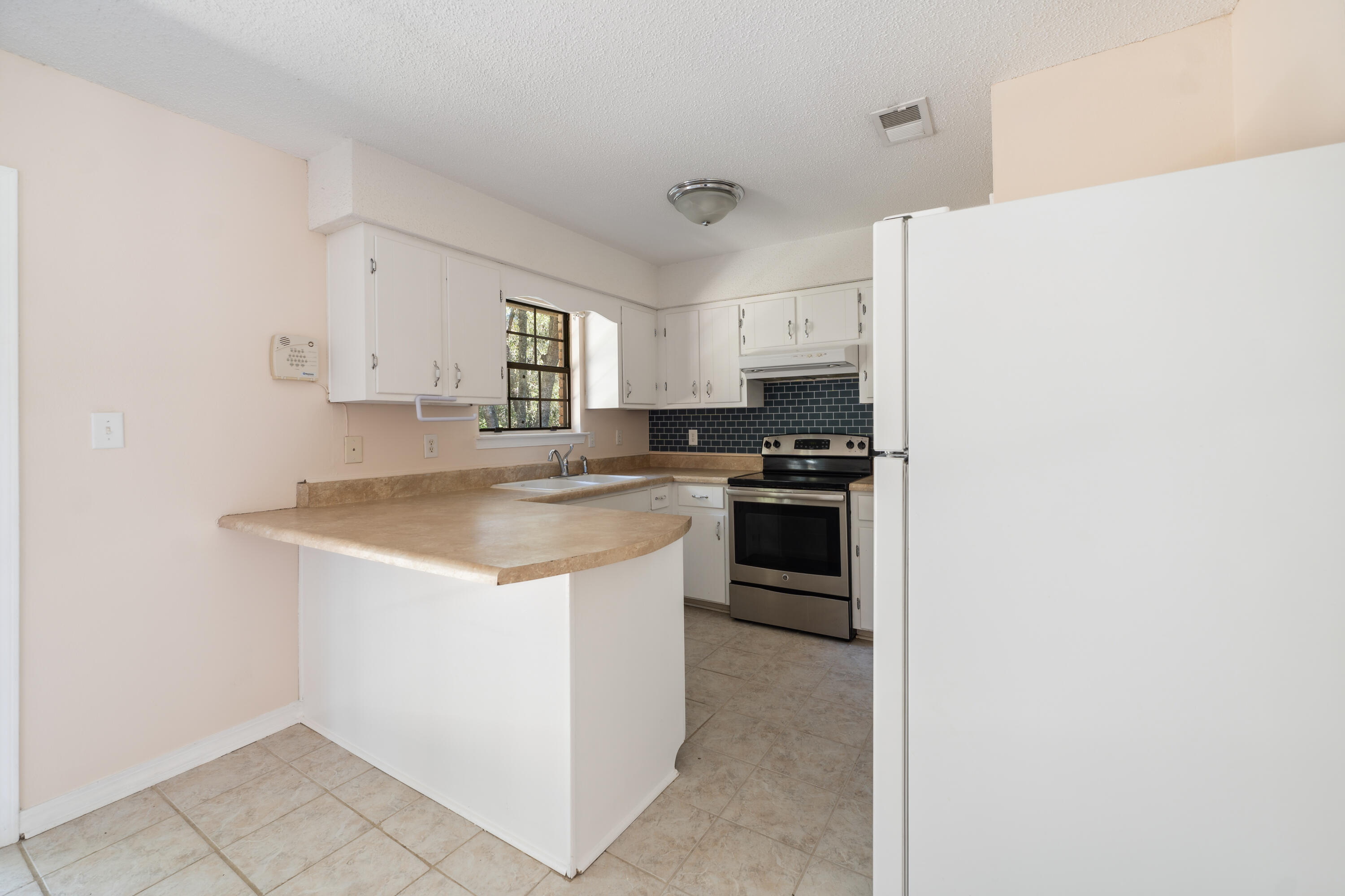6008 Old Bethel Road Crestview, FL 32536 - Photo 11 of 36 a kitchen with a sink a stove and refrigerator