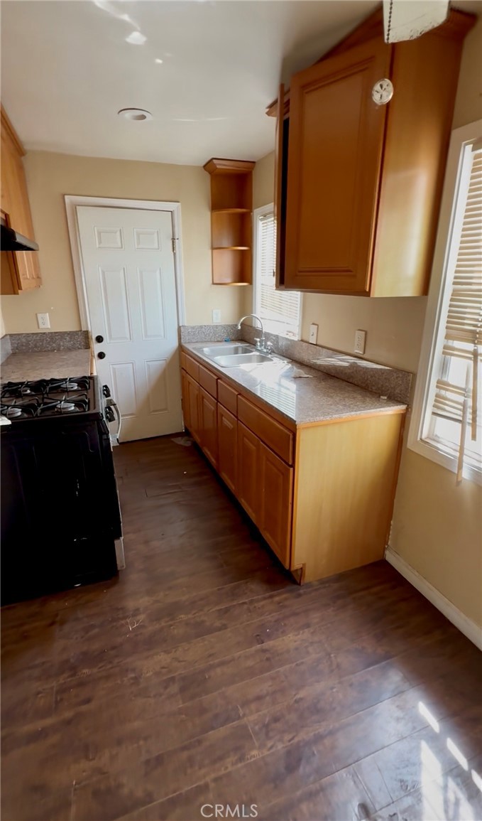2618 East 124th Street Compton, CA 90222 - Photo 7 of 16 a kitchen with stainless steel appliances granite countertop a sink and a stove top oven