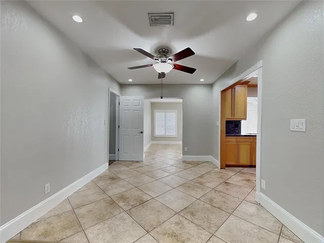 a view of an empty room and a ceiling fan