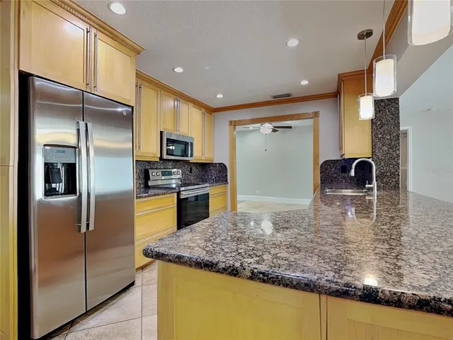 a kitchen with stainless steel appliances granite countertop a refrigerator and a sink