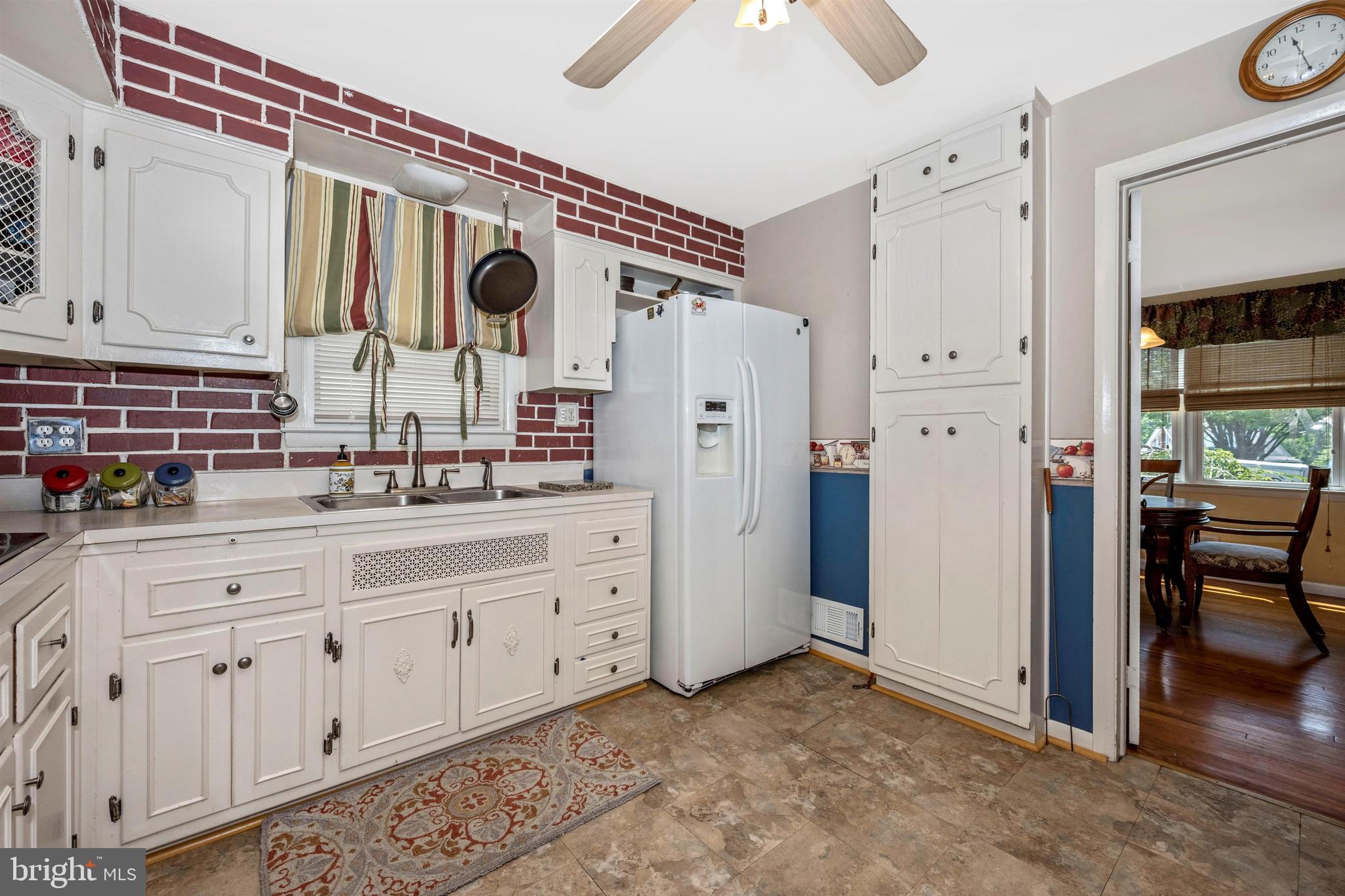 4304 Ridge Avenue Baltimore, MD 21227 - Photo 14 of 50 a kitchen with stainless steel appliances granite countertop a refrigerator and a sink