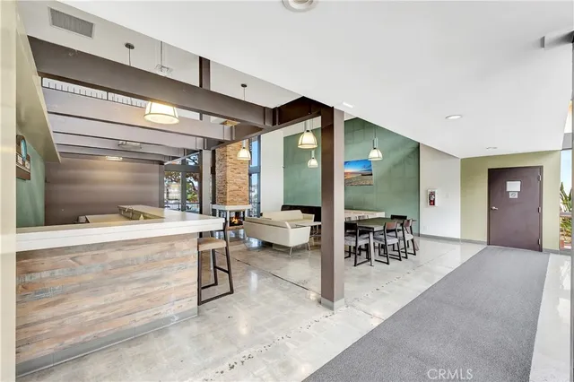 a dining hall with stainless steel appliances kitchen island granite countertop a table and chairs