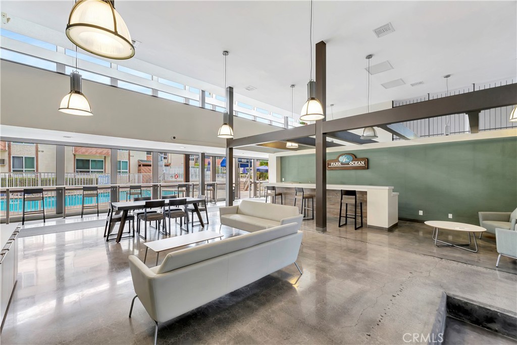 5585 Pacific Coast Highway, Unit 342 Long Beach, CA 90804 - Photo 19 of 32 a living room with couches a dining table with chandelier and couches with wooden floor
