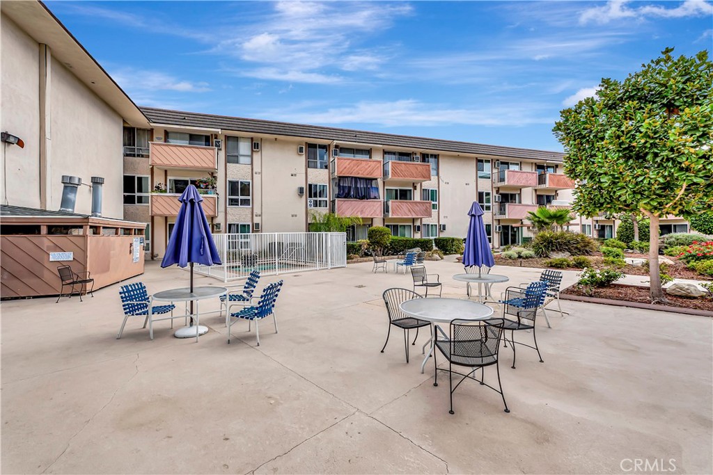 5585 Pacific Coast Highway, Unit 342 Long Beach, CA 90804 - Photo 29 of 32 a view of a patio with a table and chairs and potted plants