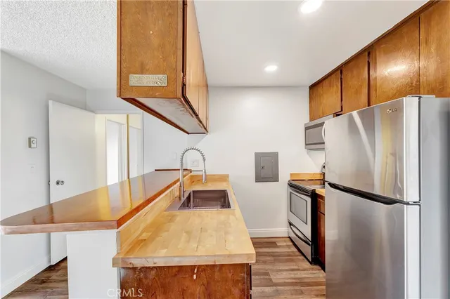 a kitchen with stainless steel appliances granite countertop refrigerator sink and cabinets
