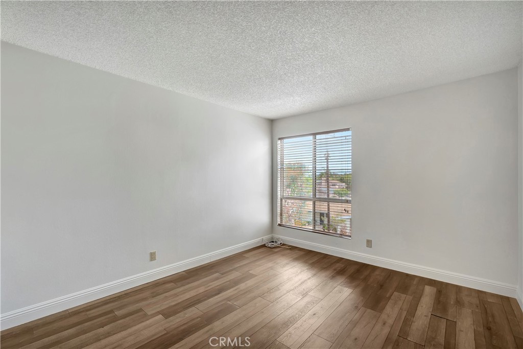 5585 Pacific Coast Highway, Unit 342 Long Beach, CA 90804 - Photo 10 of 32 an empty room with wooden floor and window