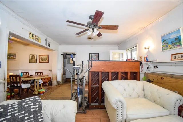 a living room with furniture kitchen view and a chandelier
