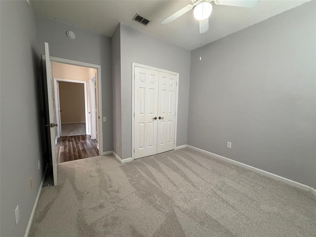 13560 Turtle Marsh Loop, Unit 332 Orlando, FL 32837 - Photo 11 of 16 an empty room with a mirror and a ceiling fan