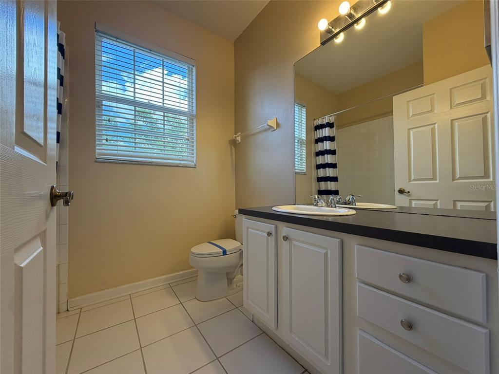 13560 Turtle Marsh Loop, Unit 332 Orlando, FL 32837 - Photo 13 of 16 a bathroom with a sink a toilet and mirror