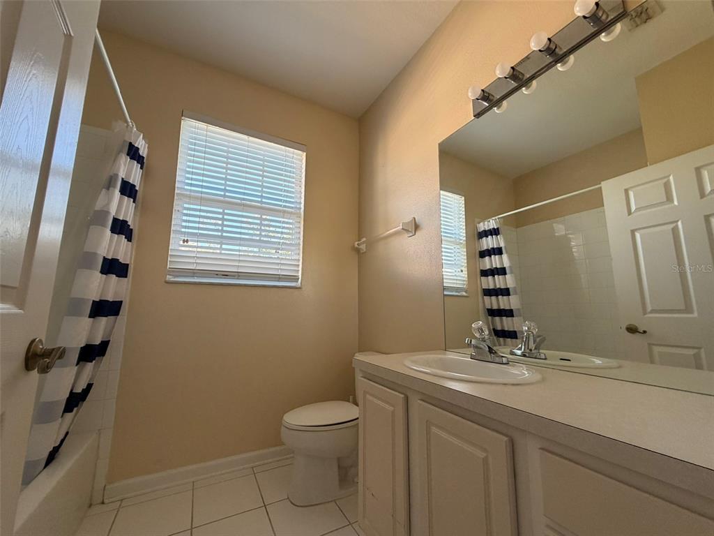 13560 Turtle Marsh Loop, Unit 332 Orlando, FL 32837 - Photo 15 of 16 a bathroom with a granite countertop sink a toilet and a mirror