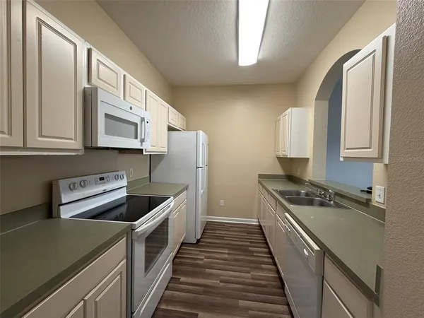 a kitchen with stainless steel appliances a sink a stove and cabinets