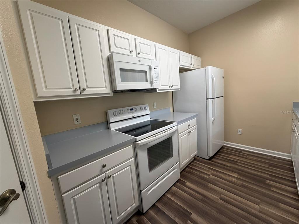 13560 Turtle Marsh Loop, Unit 332 Orlando, FL 32837 - Photo 5 of 16 a kitchen with white cabinets and white appliances
