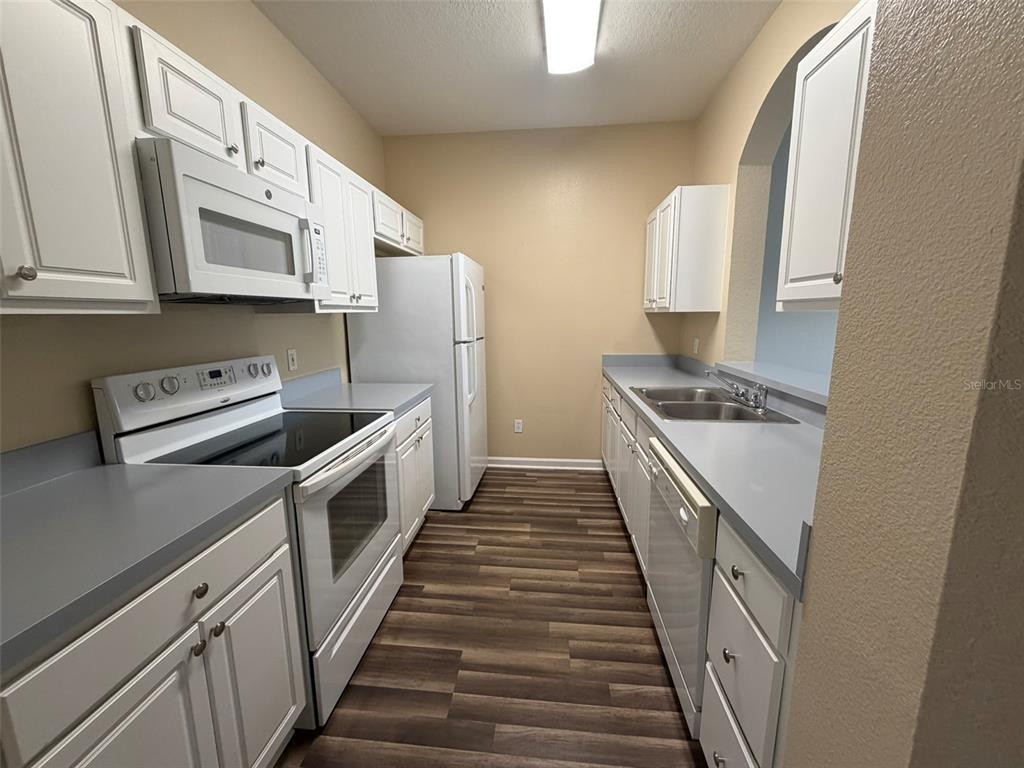 13560 Turtle Marsh Loop, Unit 332 Orlando, FL 32837 - Photo 6 of 16 a kitchen with white cabinets and white appliances