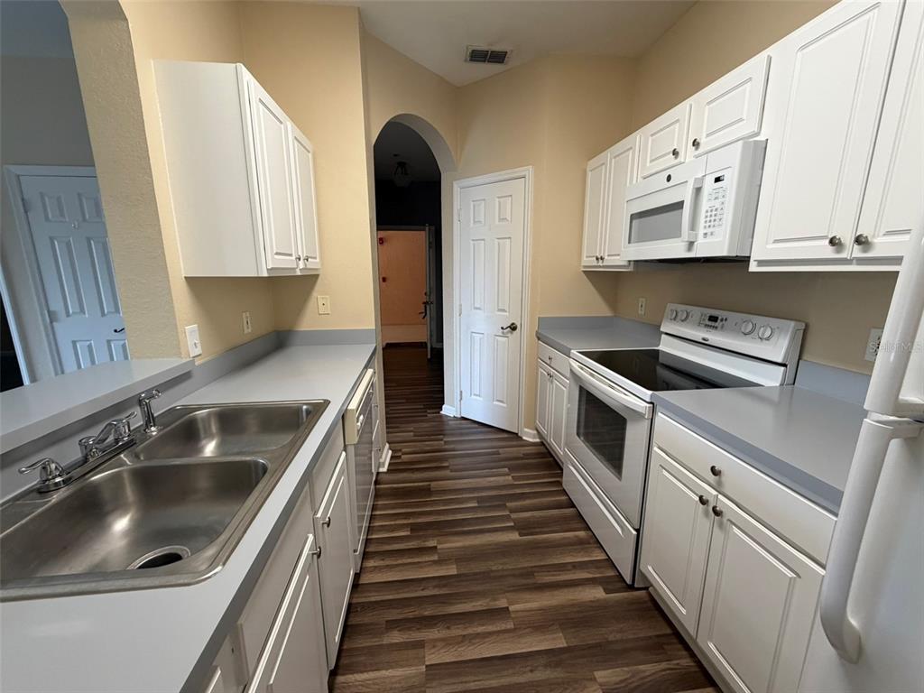 13560 Turtle Marsh Loop, Unit 332 Orlando, FL 32837 - Photo 8 of 16 a kitchen with white cabinets and sink