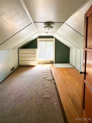 a view of an empty room with a fireplace and a window