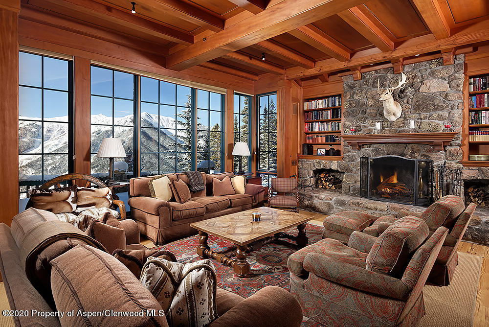 a living room with furniture a fireplace and a floor to ceiling window