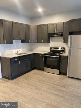 a kitchen with stainless steel appliances granite countertop a stove a sink and a refrigerator