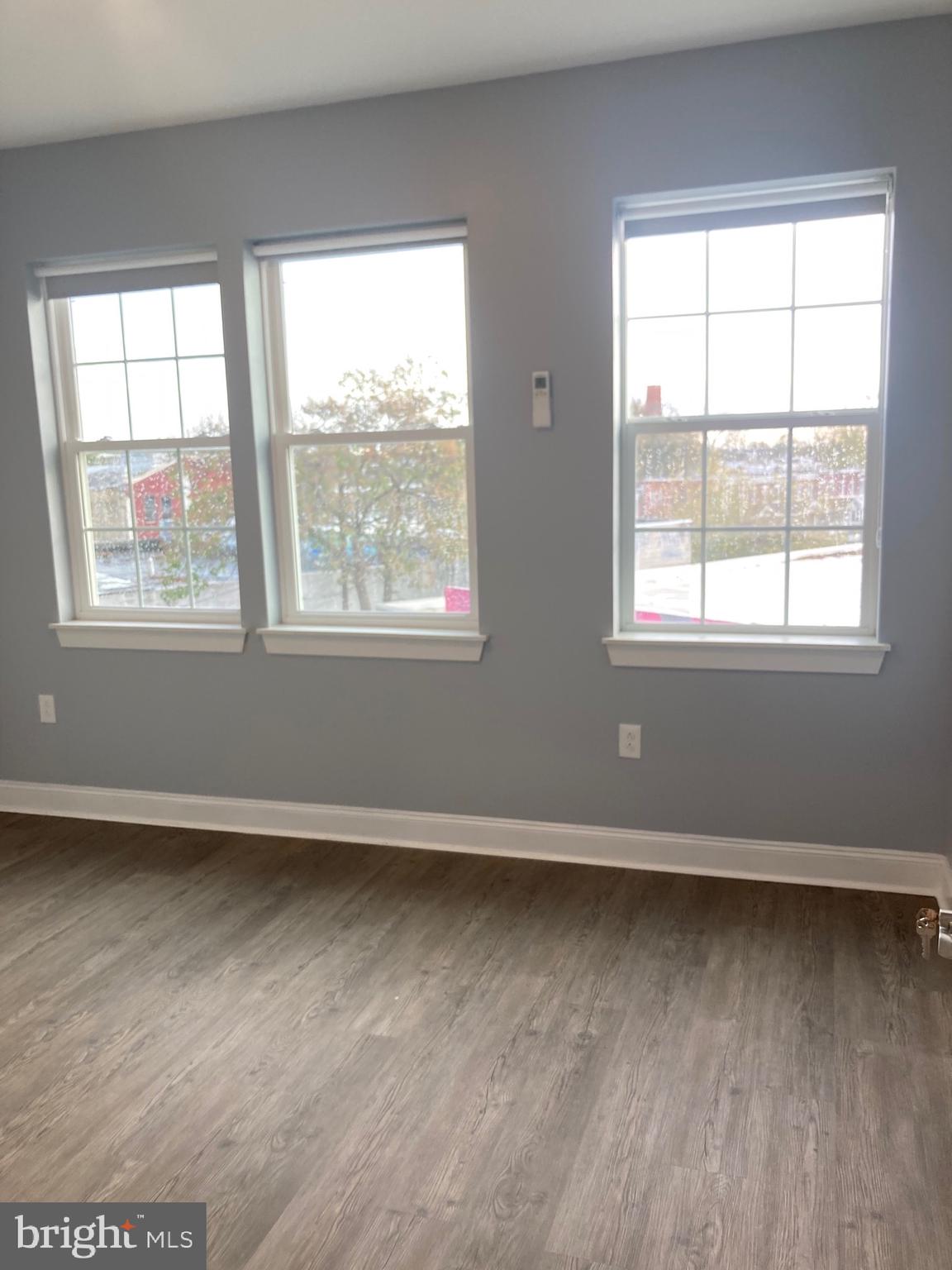 4663 Paul Street, Unit 4 Philadelphia, PA 19124 - Photo 2 of 10 an empty room with wooden floor and windows