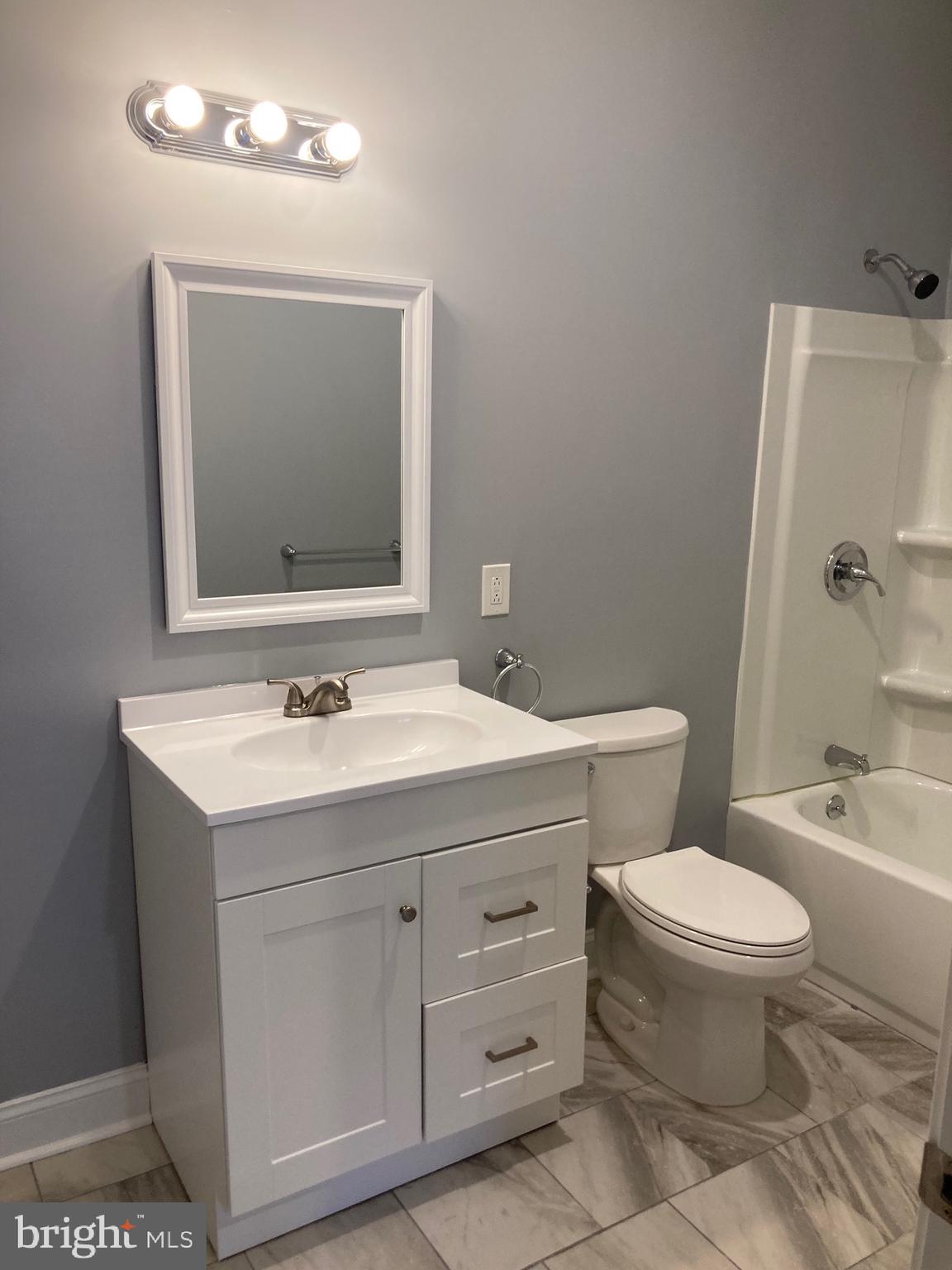 4663 Paul Street, Unit 4 Philadelphia, PA 19124 - Photo 5 of 10 a bathroom with a toilet sink and mirror