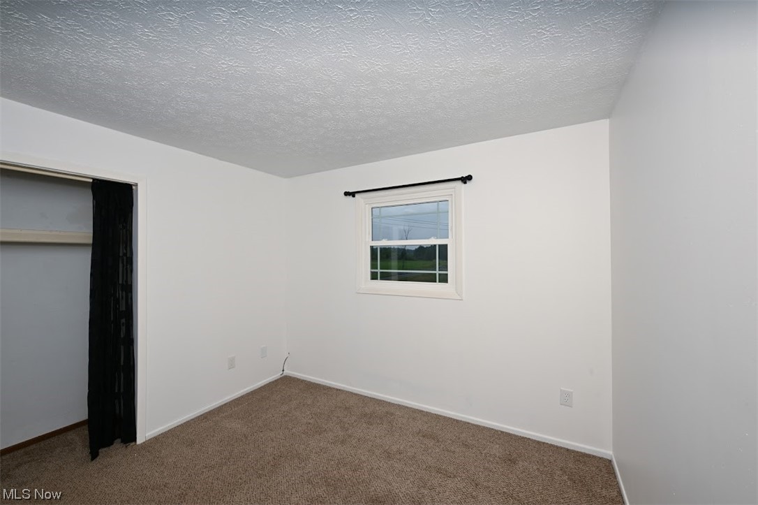 3368 Erhart Road Litchfield, OH 44253 - Photo 27 of 35 Carpeted bedroom with a textured ceiling