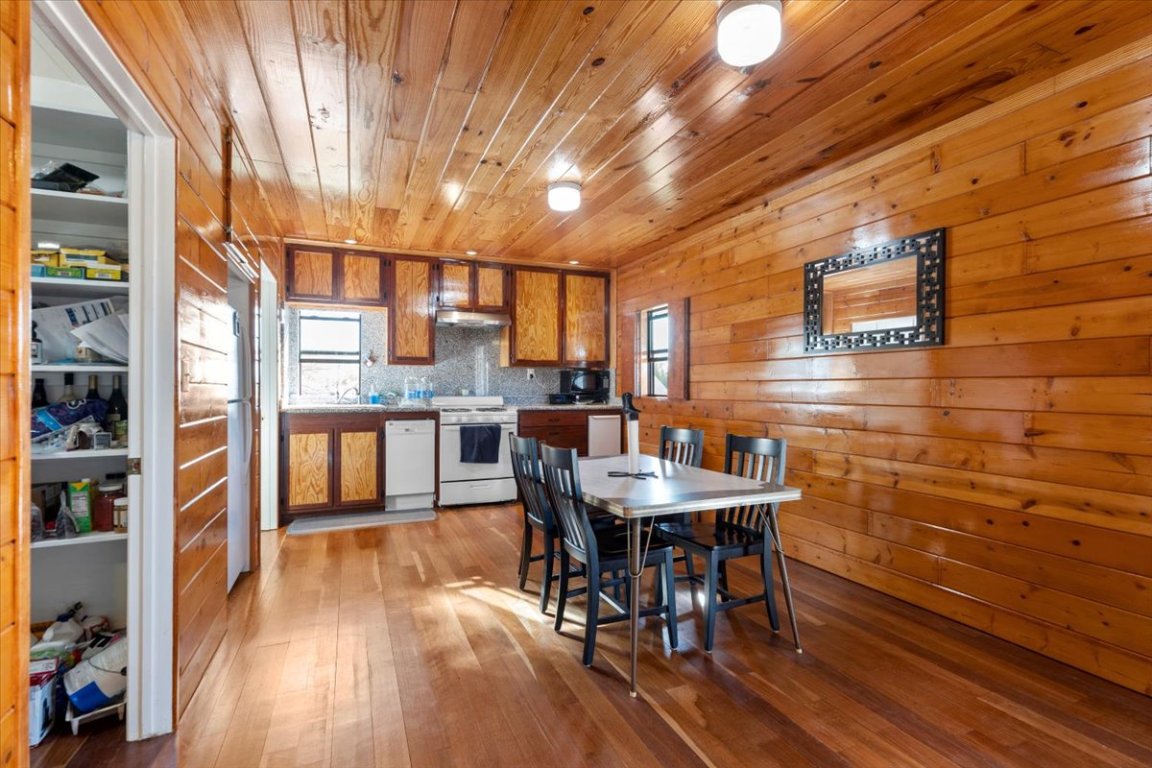 4339 Pettytown Road Dale, TX 78616 - Photo 15 of 33 Dining space with light wood-style flooring, wooden walls, and wood ceiling