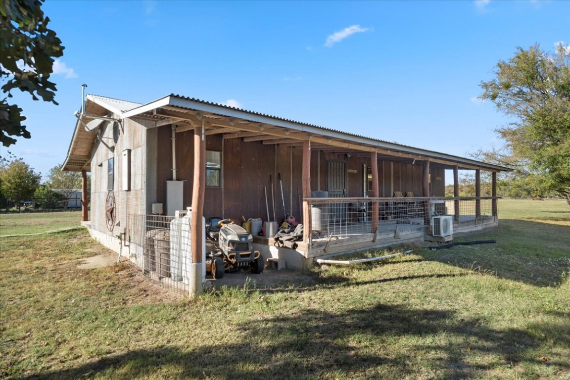4339 Pettytown Road Dale, TX 78616 - Photo 26 of 33 View of property exterior featuring a metal roof, an outbuilding, an exterior structure, covered porch, and a lawn