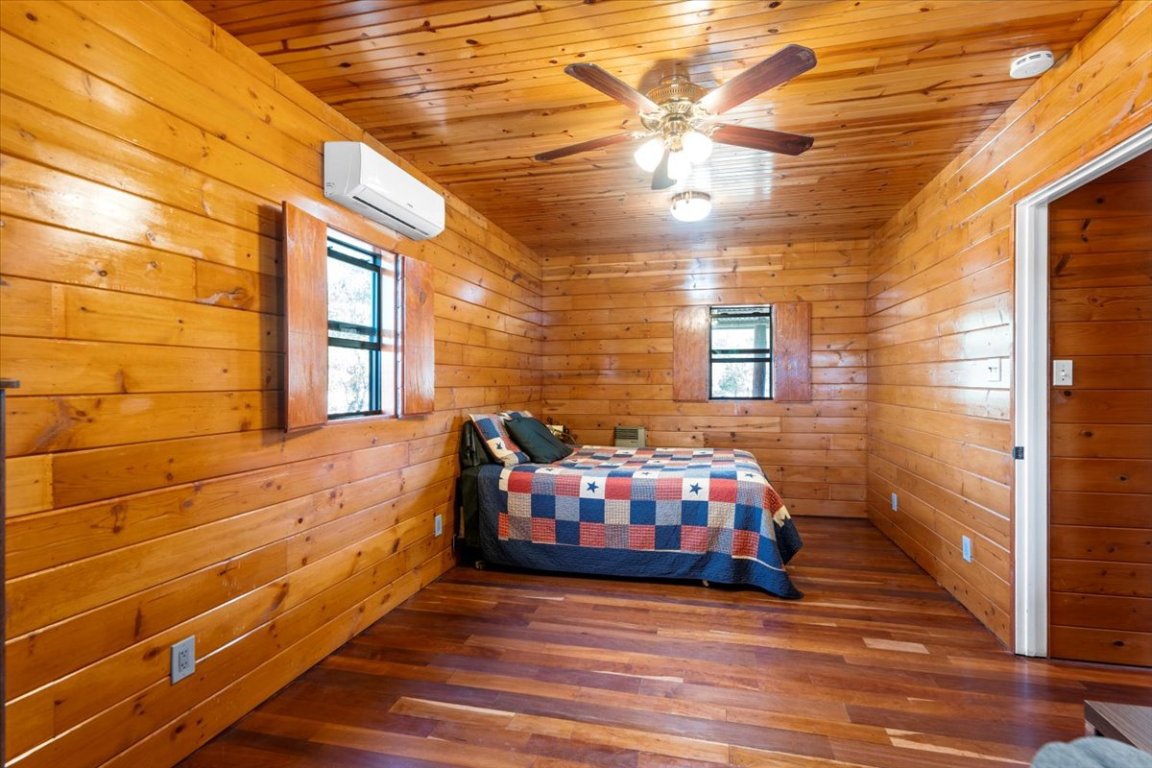 4339 Pettytown Road Dale, TX 78616 - Photo 9 of 33 Bedroom with wood finished floors, ceiling fan, wooden ceiling, and wooden walls