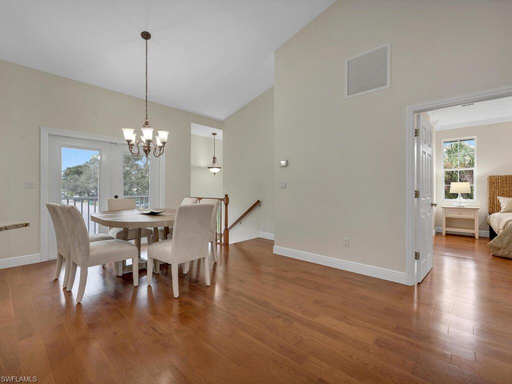 558 Corbel Drive Naples, FL 34110 - Photo 6 of 22 a view of a dining room with furniture wooden floor and chandelier