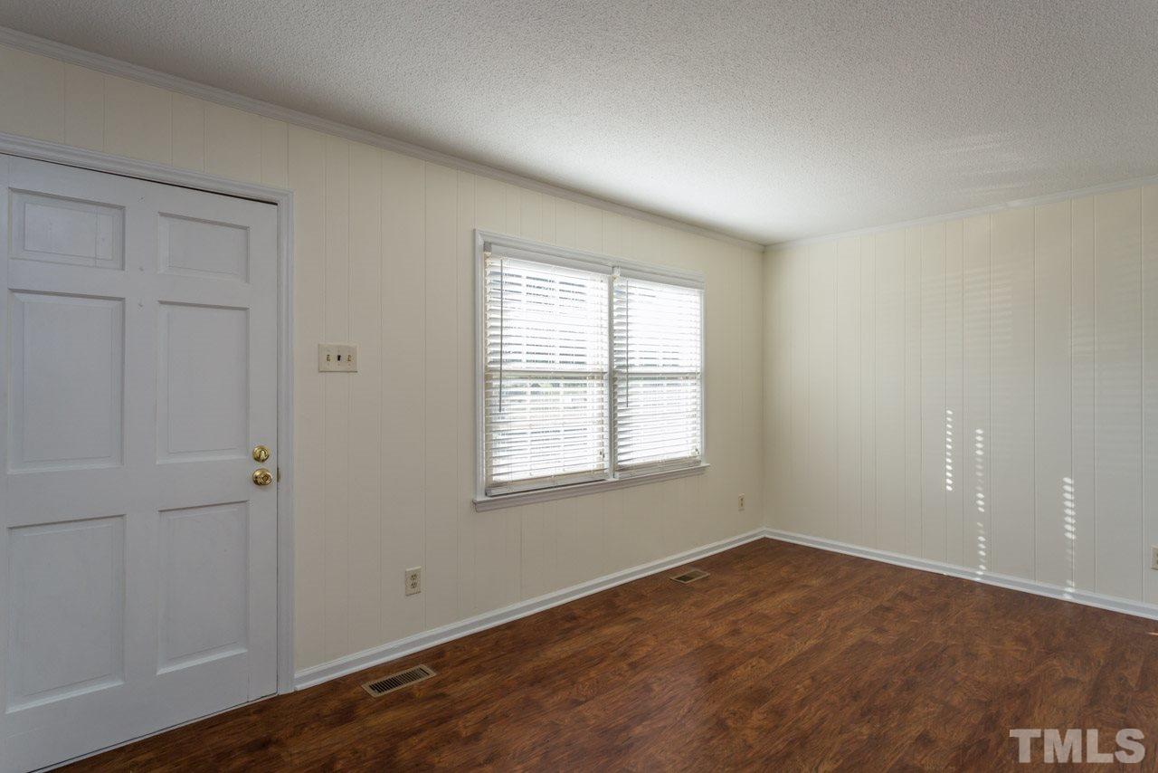 5405 Cheek Road Durham, NC 27704 - Photo 4 of 24 an empty room with wooden floor and windows