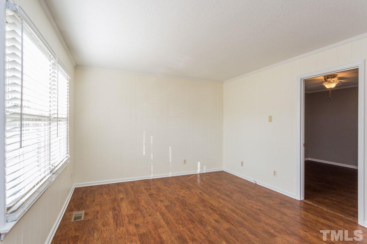 5405 Cheek Road Durham, NC 27704 - Photo 5 of 24 an empty room with wooden floor and windows