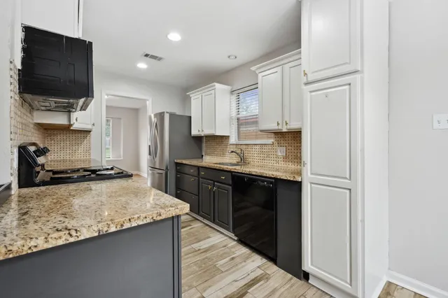 a kitchen with stainless steel appliances granite countertop a stove top oven a sink and a granite counter tops